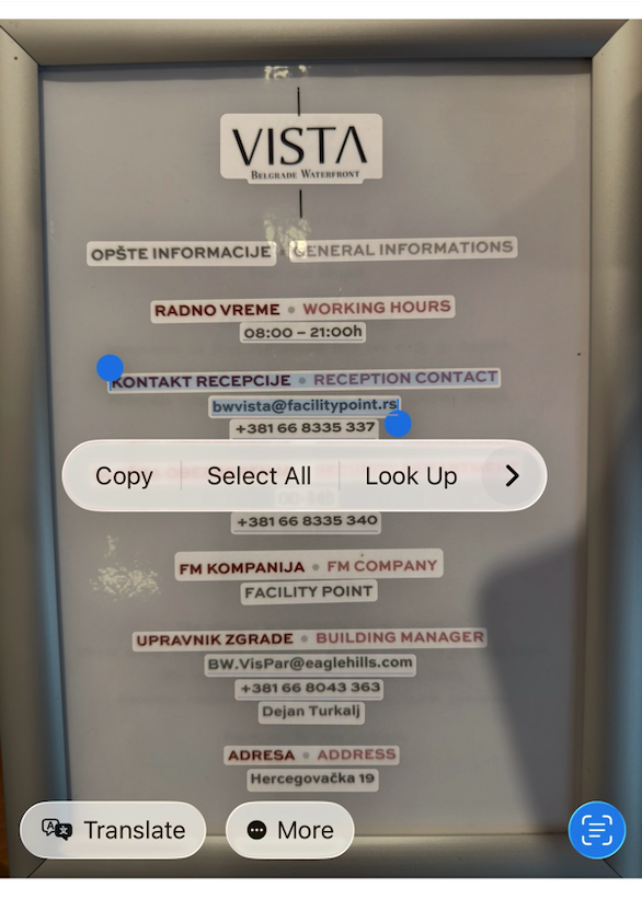 iPhone Live Text on an information board: several separate text blocks are highlighted and a Copy, Select All, Look Up menu is open over them
